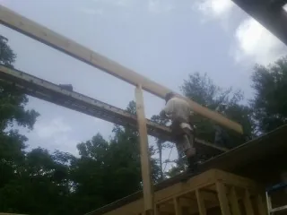 Carpenter setting a ridge beam over a new addition frame — Ice Dam Removal by Roofing Brothers in Lawrence Township
