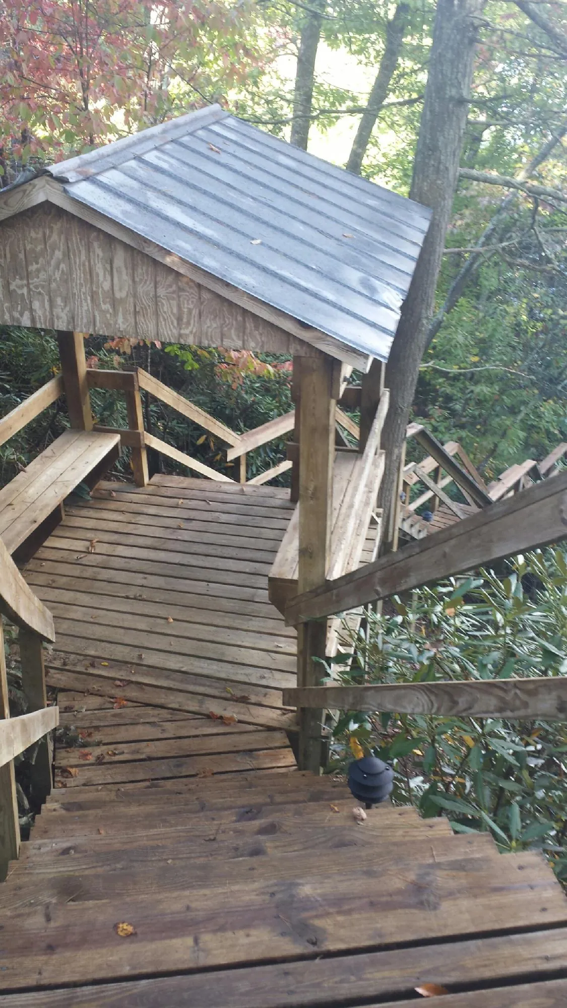 Metal roofed shelter over wooden steps on a wooded walkway — Skylight Repair & Installation work by our crew in Lawrence Township