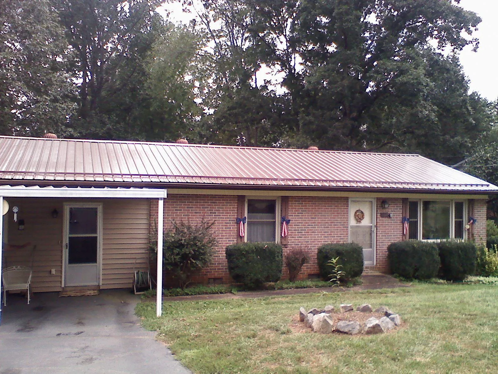 Bronze metal roof and carport on a brick ranch home — Roof Repair work by our crew in Lawrence Township