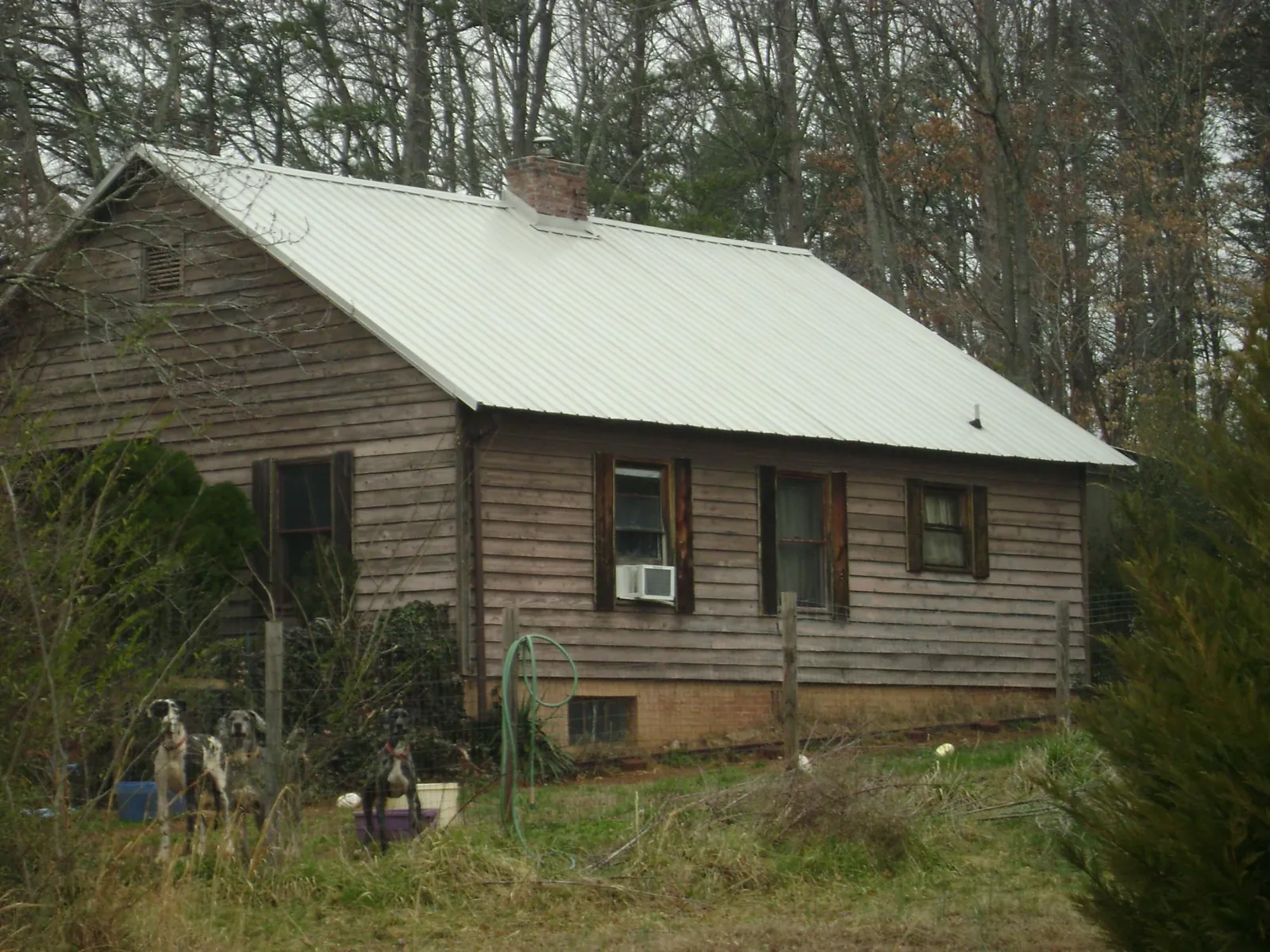 White metal roof on an old wood sided farmhouse, from a Metal Roof Installation job in Lawrence Township
